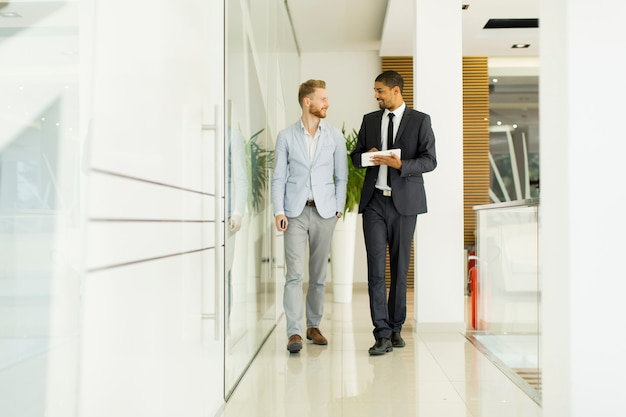 Moderne junge Männer mit Tablette im Büro