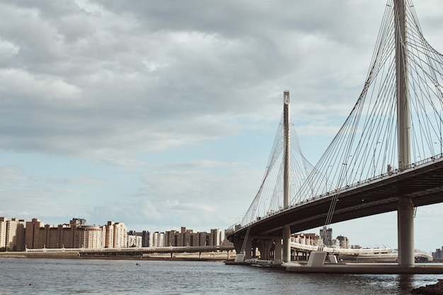 Moderne Kabelbrücke über den Fluss gegen bewölkten Himmel. Engineering Bau Nahaufnahme