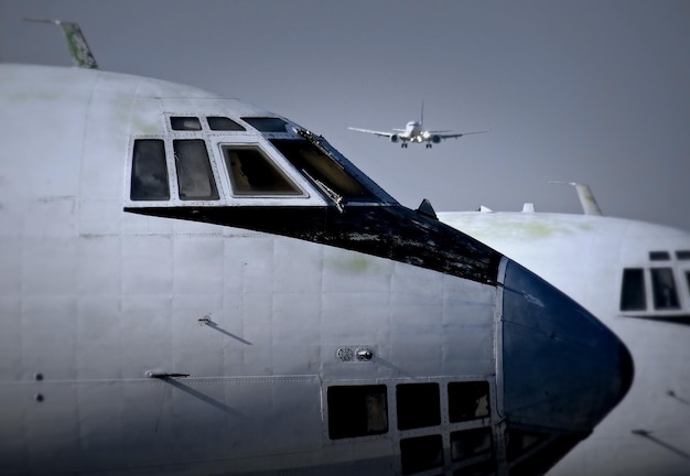 Moderne Passagierflugzeuge, die über alten Flugzeugen am Flughafen landen