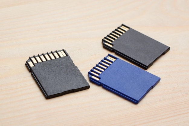 Moderne schnelle SD-Speicherkarten auf Holztisch, die in verschiedenen Geräten verwendet werden können