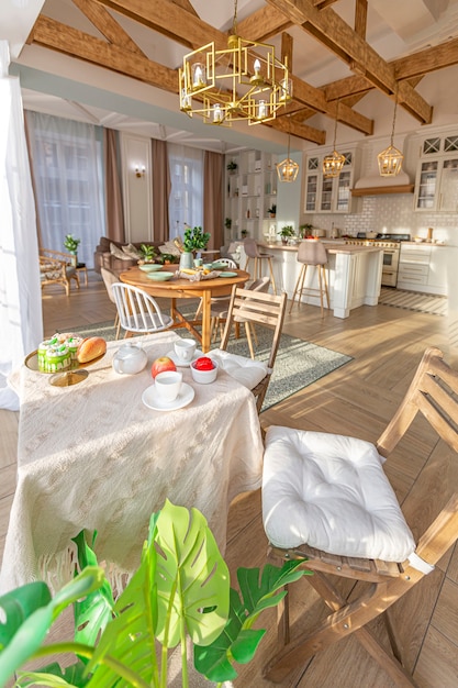 Moderne teure luxuriöse offene Wohnung. Reichhaltiges Interieur im skandinavischen Stil mit Holzbalken an der Decke in Pastellfarben