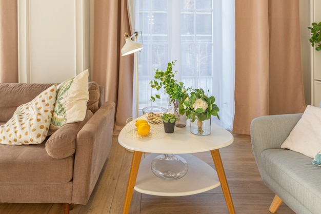 Moderne teure luxuriöse offene Wohnung. Reichhaltiges Interieur im skandinavischen Stil mit Holzbalken an der Decke in Pastellfarben