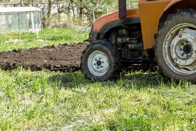 Moderne Traktormaschinen, die im Frühling und Herbst landwirtschaftliche Wiesen auf dem Bauernhof pflügen.