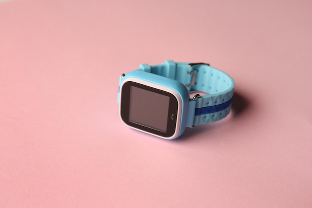 Moderne, trendige Smartwatch für Kinder auf rosa Hintergrund