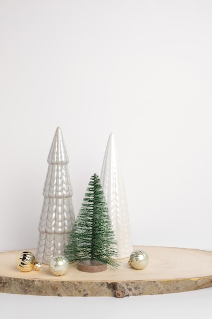 Moderne Weihnachtsbäume Dekorative beige weiße und grüne Weihnachtsdekoration auf einem Holzständer mit grauem Hintergrund Nordische festliche Dekoration Boho skandinavischer Stil Design trendige minimale Verzierung