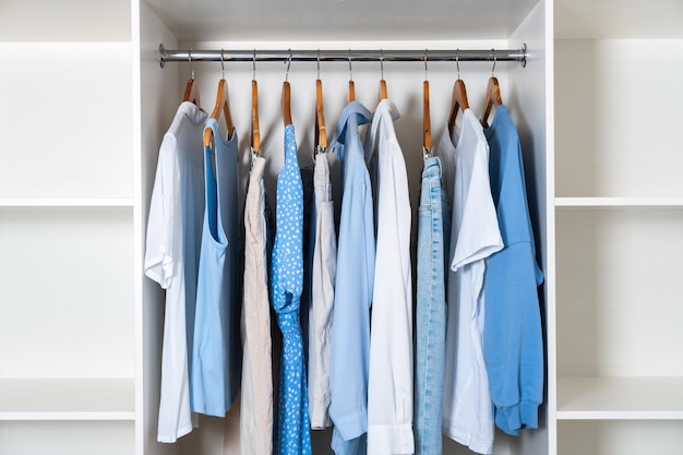 Foto moderne weiße garderobe mit weißer und blauer kleidung organisation der lagerung im schrank