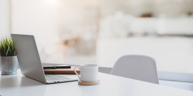 Moderner Arbeitsplatz mit Laptop-Computer, Kaffeetasse und Bürozubehör