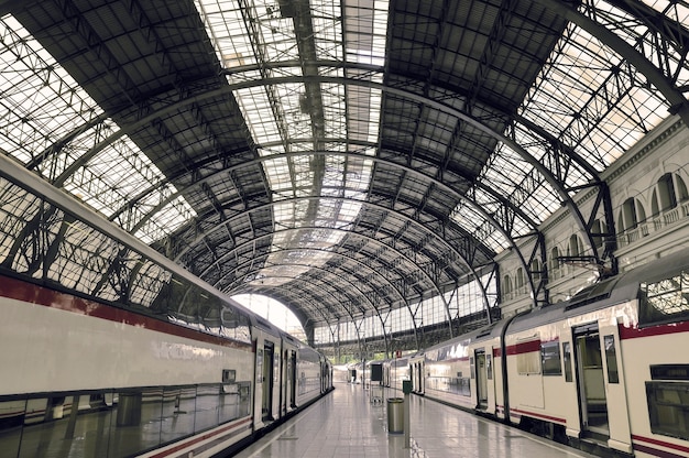 Moderner Bahnhof mit wartenden Eisenbahnwaggons und Bogenmetalldach