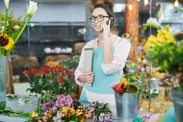 Moderner Florist, der per Telefon spricht