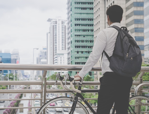 Moderner Geschäftsmann fährt Fahrrad, um zu arbeiten, Stau in der beschäftigten Stadt zu vermeiden