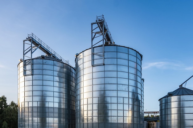 Moderner Granary-Elevator mit Silbersilos auf Agroverarbeitungs- und Produktionsanlage zur Verarbeitung, Trocknung, Reinigung und Lagerung von landwirtschaftlichen Produkten, Mehl, Getreide und Getreide