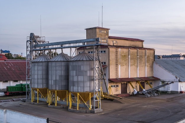 Moderner Granary-Elevator mit Silbersilos auf Agroverarbeitungs- und Produktionsanlage zur Verarbeitung, Trocknung, Reinigung und Lagerung von landwirtschaftlichen Produkten, Mehl, Getreide und Getreide
