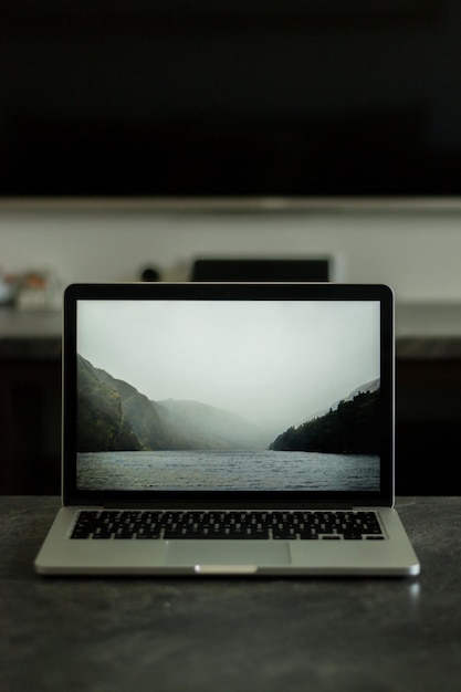 Foto moderner grauer laptop mit schwarzen tastaturen auf grauer oberfläche