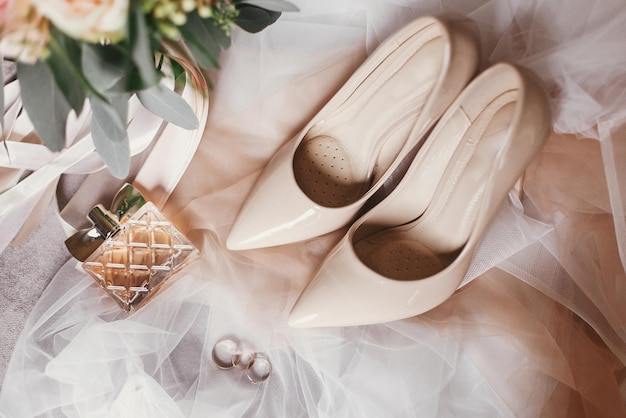 Moderner Hochzeitsstrauß aus rosa Rosen und grünen Eukalyptus-Beige-Schuhen Parfümringe auf weichem Stoff Zeitgenössische Komposition aus stilvollem Brautaccessoire für die Draufsicht der Hochzeit
