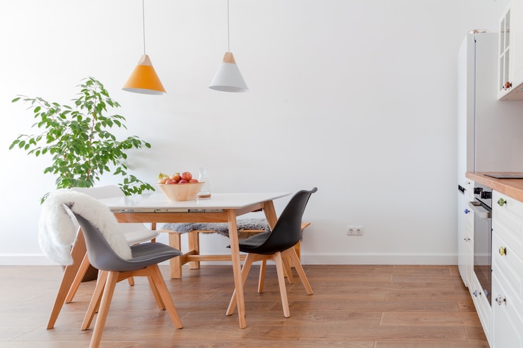 Foto moderner innenraum des esszimmers, weiße möbel, lampen über holztisch, stühle, äpfel, schüssel