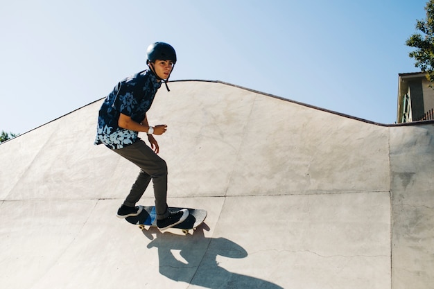 Moderner Kerl posiert während skateboarding