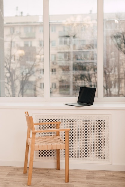 Moderner, komfortabler Arbeitsplatz am Fenster mit Laptop