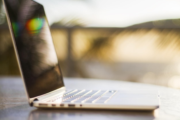 Moderner Laptop bei Sonnenuntergang mit geringer Schärfentiefe