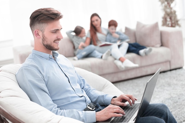 Moderner Mann mit Laptop in seinem Wohnzimmer