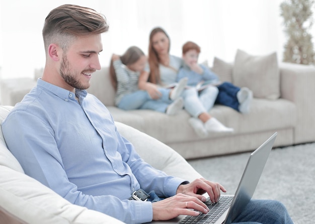 Moderner Mann mit Laptop in seinem Wohnzimmer