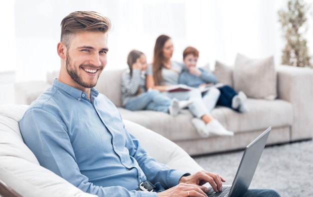 Moderner Mann mit Laptop in seinem Wohnzimmer