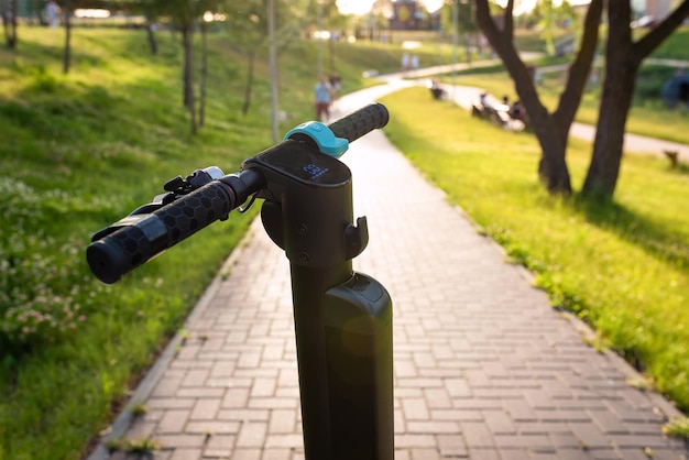 Moderner Roller auf der Straße im Park an einem sonnigen Tag urbaner Lebensstil