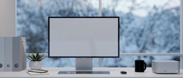 Moderner Schreibtisch mit Computermodellzubehör und Dekor über dem Fenster mit Schneeblick