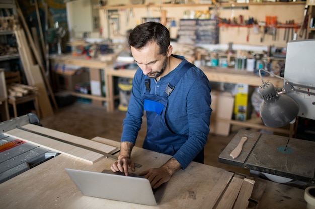 Moderner Schreiner mit Laptop