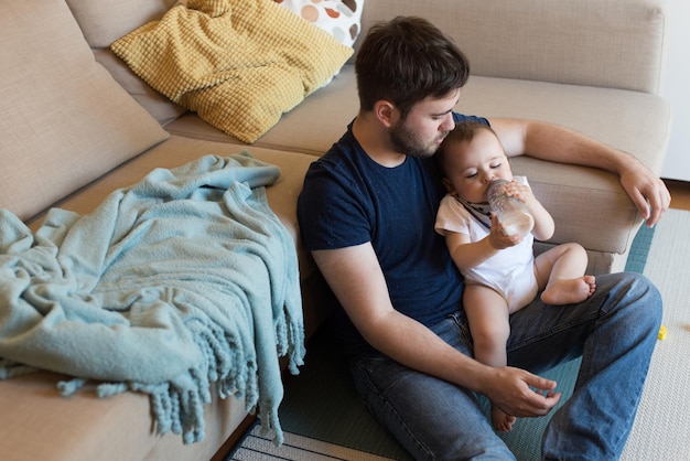 Moderner Vater, der mit kleinem Baby spielt