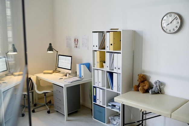 Foto modernes büro des kinderarztes mit arbeitsplatz und schrank mit ordnern