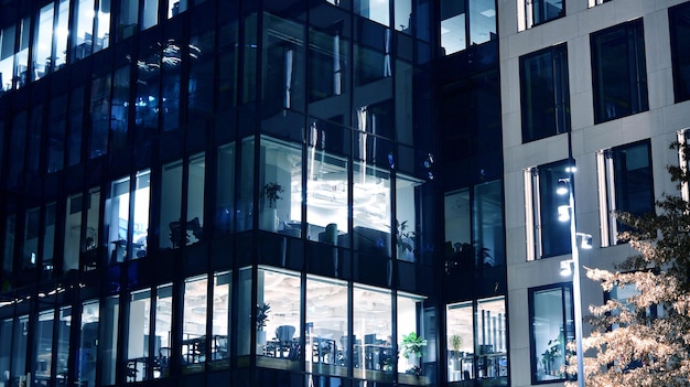 Modernes Bürogebäude in der Stadt bei Nacht. Blick auf beleuchtete Büros eines Firmengebäudes