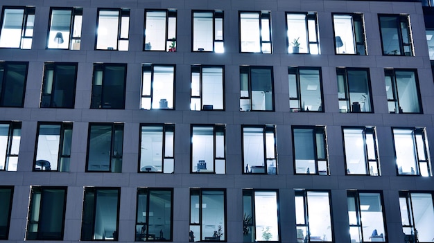 Modernes Bürogebäude in der Stadt bei Nacht. Blick auf beleuchtete Büros eines Firmengebäudes