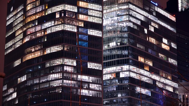 Modernes Bürogebäude in der Stadt bei Nacht. Blick auf beleuchtete Büros eines Firmengebäudes