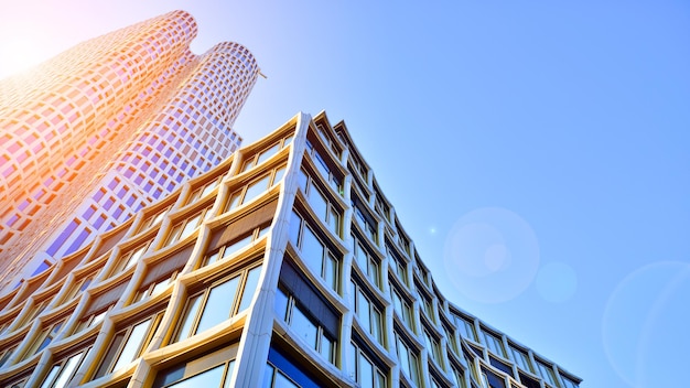 Modernes Bürogebäude mit Glasfassade vor klarem Himmel im Hintergrund. Transparente Glaswand