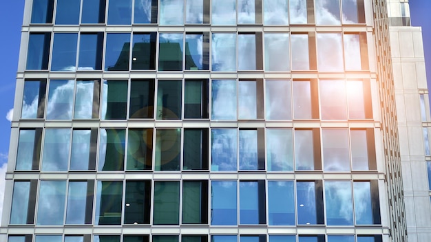 Modernes Bürogebäude mit Glasfassade vor klarem Himmel im Hintergrund. Transparente Glaswand