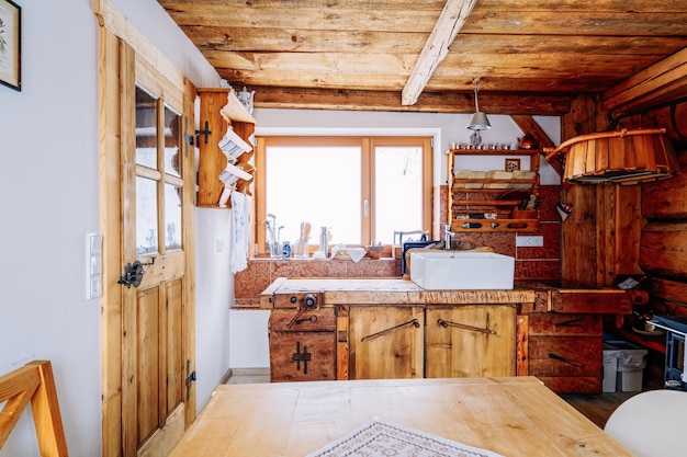 Modernes Design von Home Kitchen Interior aus Holz. Holzmöbel im Haus. Esszimmer. Braune Farbe. Tisch und Waschbecken. Windows im Hintergrund. Zeitgenössisches rustikales und handgefertigtes Vintage-Dekor
