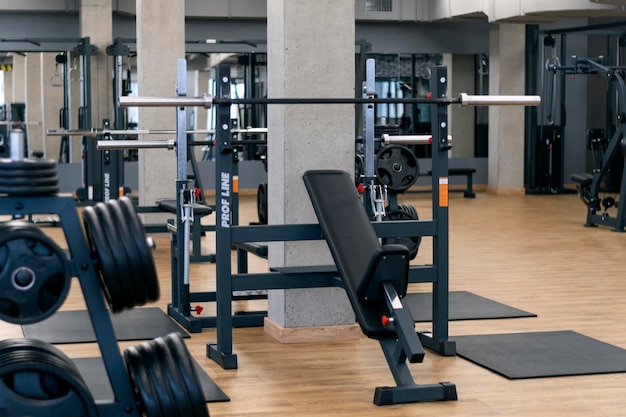 Modernes Fitnessstudio mit verschiedenen Trainingsgeräten. Sportsimulatoren und Hanteln.