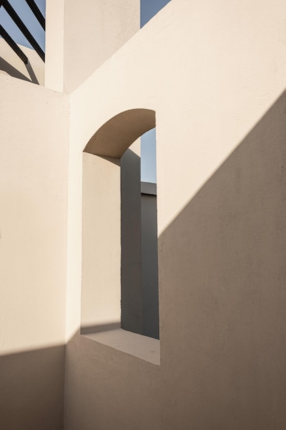 Modernes Gebäude im Oststil mit beigen Wänden, Fenstern und Sonnenlichtschatten Ästhetisches abstraktes Fassadendesign mit minimaler Architektur