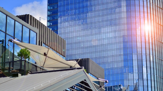 Modernes Glasgebäude mit blauem Himmelshintergrund. Ansicht und Architekturdetails. Urbane Zusammenfassung