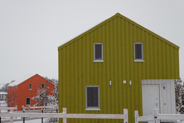 Modernes Holzhaus im skandinavischen Stil mit Wintertag in verschiedenen Farben im Dorf