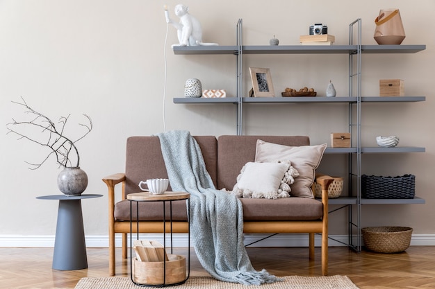 Modernes innendesign des wohnzimmers mit braunem holzsofa, grauem buchständer, vase mit blumen, couchtisch, dekoration und eleganten accessoires. beige und japanisches konzept. stilvolles homestaging.