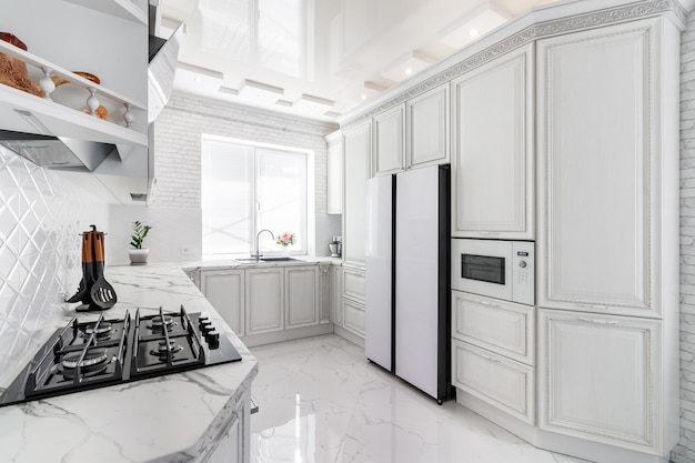 Modernes Interieur mit weißer Küche und Küchengeräten im Landhaus