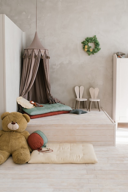 Modernes Kinderzimmer ein Zeltbett auf dem Podium Stofftiere Hochstühle in Form von Hasen