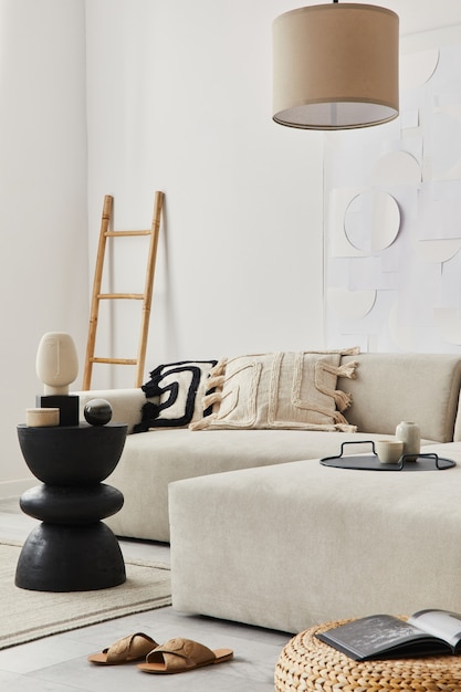 Modernes Konzept der Wohnzimmereinrichtung mit Design-Sofa, Kissen, Decke, Kunstmalerei, seitlichem Holzhocker, Lampe und eleganten persönlichen Accessoires in stilvoller Wohnkultur. Vorlage.