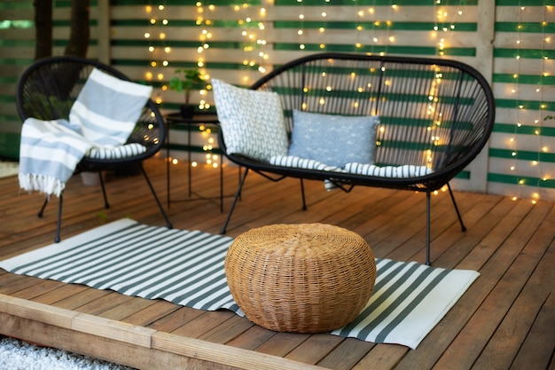 Modernes Lounge-Terrassenhaus mit Holzboden, bequemem Sofasessel und Korbhocker