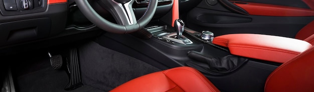 Modernes Luxusfahrzeug Innenraum Lenkrad Schalthebel und Armaturenbrett Innenraum Luxus im Inneren Lenkrad Armaturenbrettrad Geschwindigkeitsmesser Anzeige Rot und schwarzes Leder Cockpit