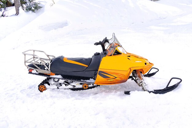 Foto modernes motorschlitten-scooter-fahrzeug auf schnee in der bergstraße mietwagen-extremsport-abenteuer