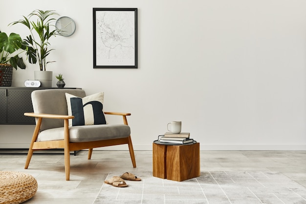 Modernes Retro-Konzept der Inneneinrichtung mit grauem Sessel des Designs, Couchtisch, Pflanzen, Plakatkarte, Teppich und persönlichem Zubehör. Stilvolle Wohnkultur des Wohnzimmers.