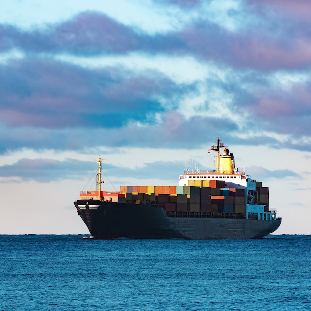 Modernes schwarzes Containerschiff, das sich von der Ostsee bewegt