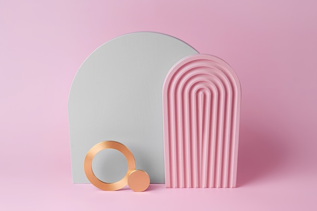 Modernes Set aus verschiedenen Materialien und geometrischen Formen. Platz kopieren. Graue und rosa Bögen und goldene Runden auf rosa Hintergrund.